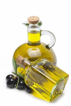 Jars with olive oil and some olives isolated over a white background.