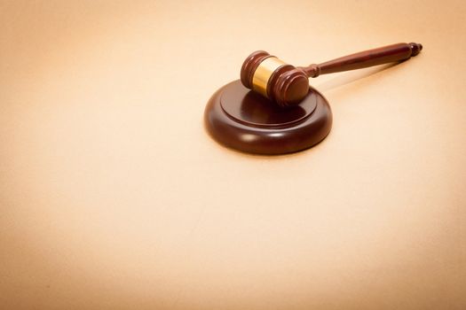 A wooden gavel and soundboard on a light brown background.