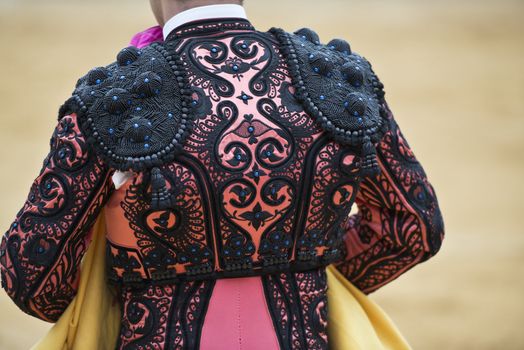 Detail of the jacket of the bullfighter in pink and black amber colors.