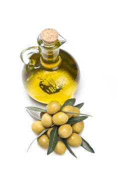 A jar with olive oil and some green olives isolated over a white background.