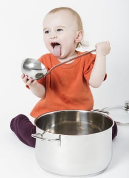 baby with big cooking pot isolated on neutral background