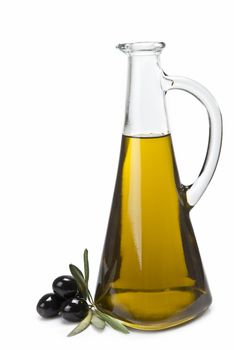 A jar with olive oil and some black olives isolated over a white background.
