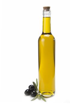 A classical glass bottle of olive oil and some black olives isolated over a white background