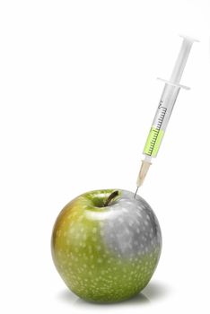 A syringe inserted  in an apple on a white background.