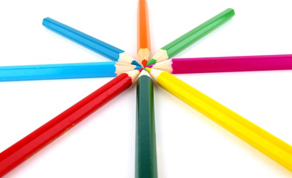 Color pencils in arrange in color wheel colors on white background 
