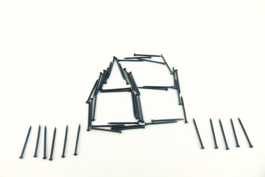 Isolate steel nails construct house with fence on white background