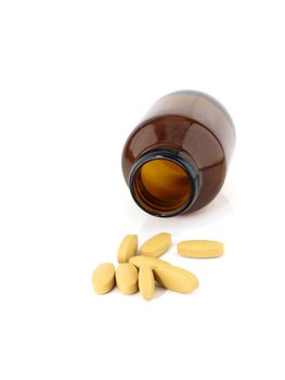 Vitamin C pills spilling from brown medicine bottle