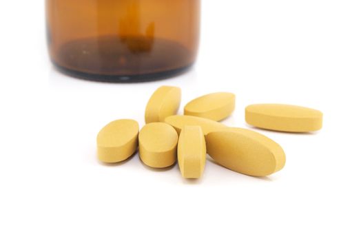 Vitamin C pills with brown medicine bottle background