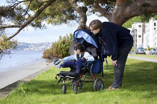 Father spending time with disabled son in wheelchair at the lake