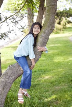Young girl resting on a tree branch