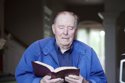 Elderly 90 yr old man reading the Bible