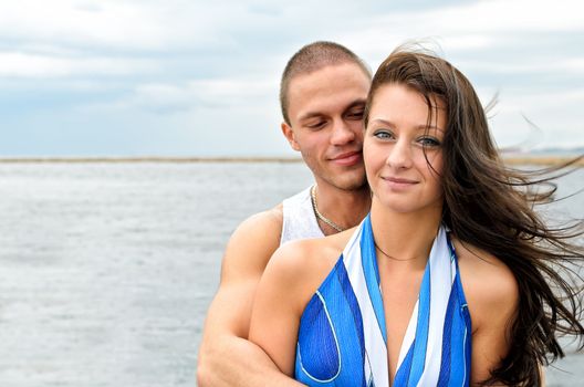 Young lovely couple against blue sea.