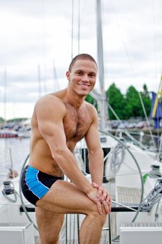 Muscular handsome sailor on his yacht.