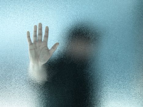 Silhouette of a man through frosted glass