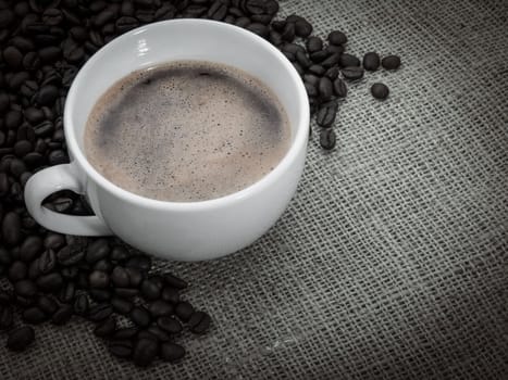 Black coffee over old burlap background
