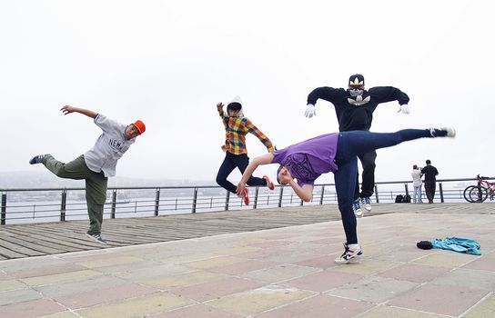 Four breakdancers jumping at the same time