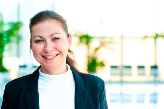 Portrait of a smiling girl on the background of the manager de-focus office interior