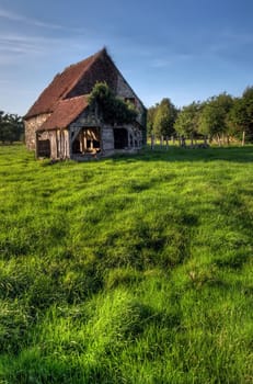 Normandy traditional old house with fresh green grass meadow