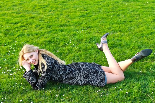 Happy girl lies on a blooming meadow in the early spring  morning