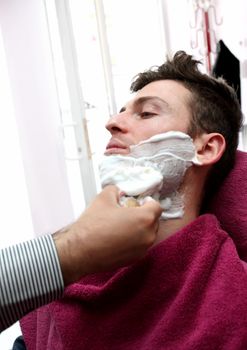 Young adult at barber shop for shaving