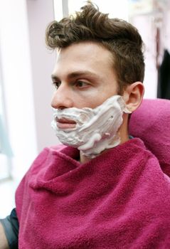 Young adult at barber shop for shaving