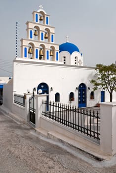 White Greek church with belltower and the yard