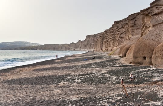 Vlichada beach in Santorini with volcanic walls and a pair of old shoes in front
