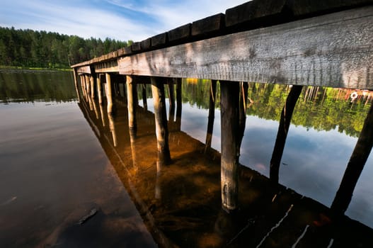 Hand made pier on lake close up, beautiful landscape and reflection
