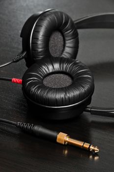 High quality headphones laying on dark and wooden table