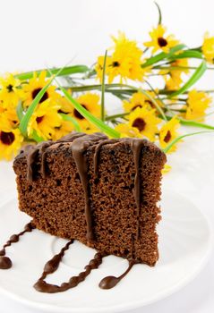 Gingerbread on plate. Yellow flowers in background