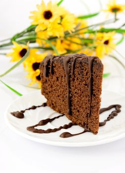 Gingerbread on plate. Yellow flowers in background