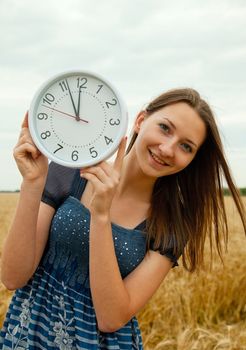 Teen girl holds watches staying outdoors