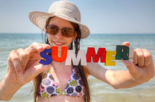 Teen girl at a beach with word 'Summer!"