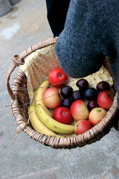 woman holds a basket of fruit