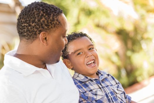 Happy African American Father and Mixed Race Son Talking in the Park.