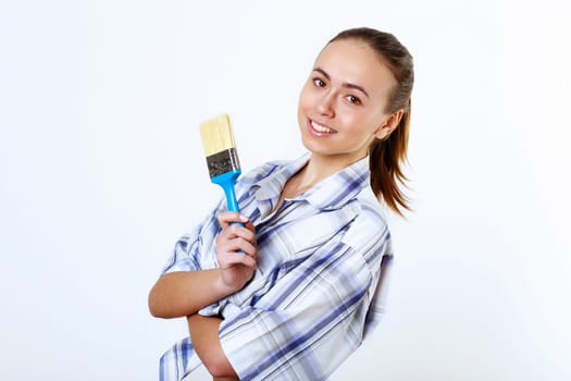Portrait of young woman with paint brushes