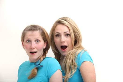 Two shocked and surprised women with wide eyed expressions and their mouths open as they gaze at the camera