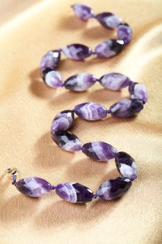 Beads from violet glass against from a fabric