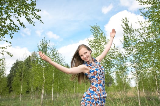 The girl with the lifted hands against  blue sky