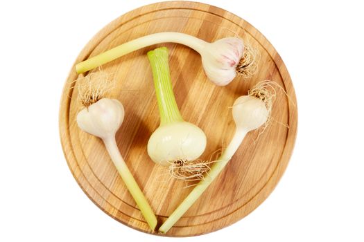 Garlic and onions heads on a chopping board.White background