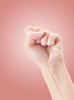 Fist. Gesture of the hand on pink background.