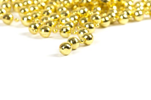 Background made of a brilliant celebratory beads of golden color over white