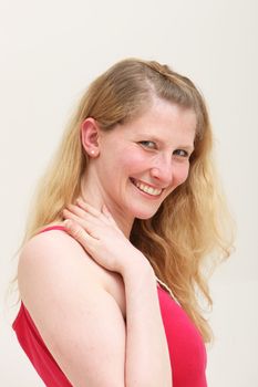 Elated attractive middle-aged blonde woman smiling in pleasure as she looks down at the camera, studio portrait isolated on white