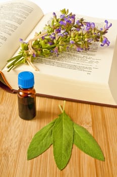 sage with herbal tincture and medieval book