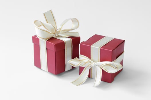 Two gifts with bright ribbons on a neutral background.