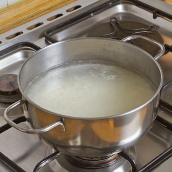 Close up of a pot with boiling rice inside