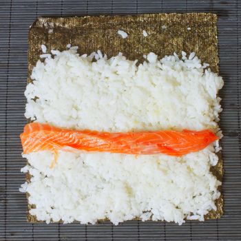 Detail of preparation of sushi: roll of salmon over the rice