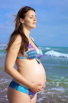 beautiful pregnant female model relaxing in front of the sea