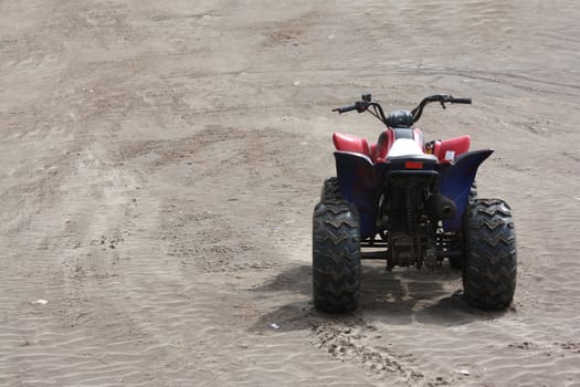 A beach buggy without a rider, on the beach sands.