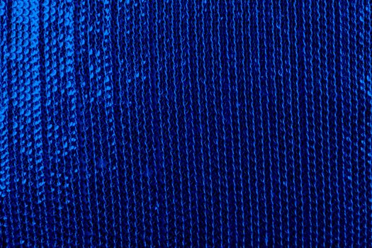 A background of a fabric with sequins, in dark blue color.